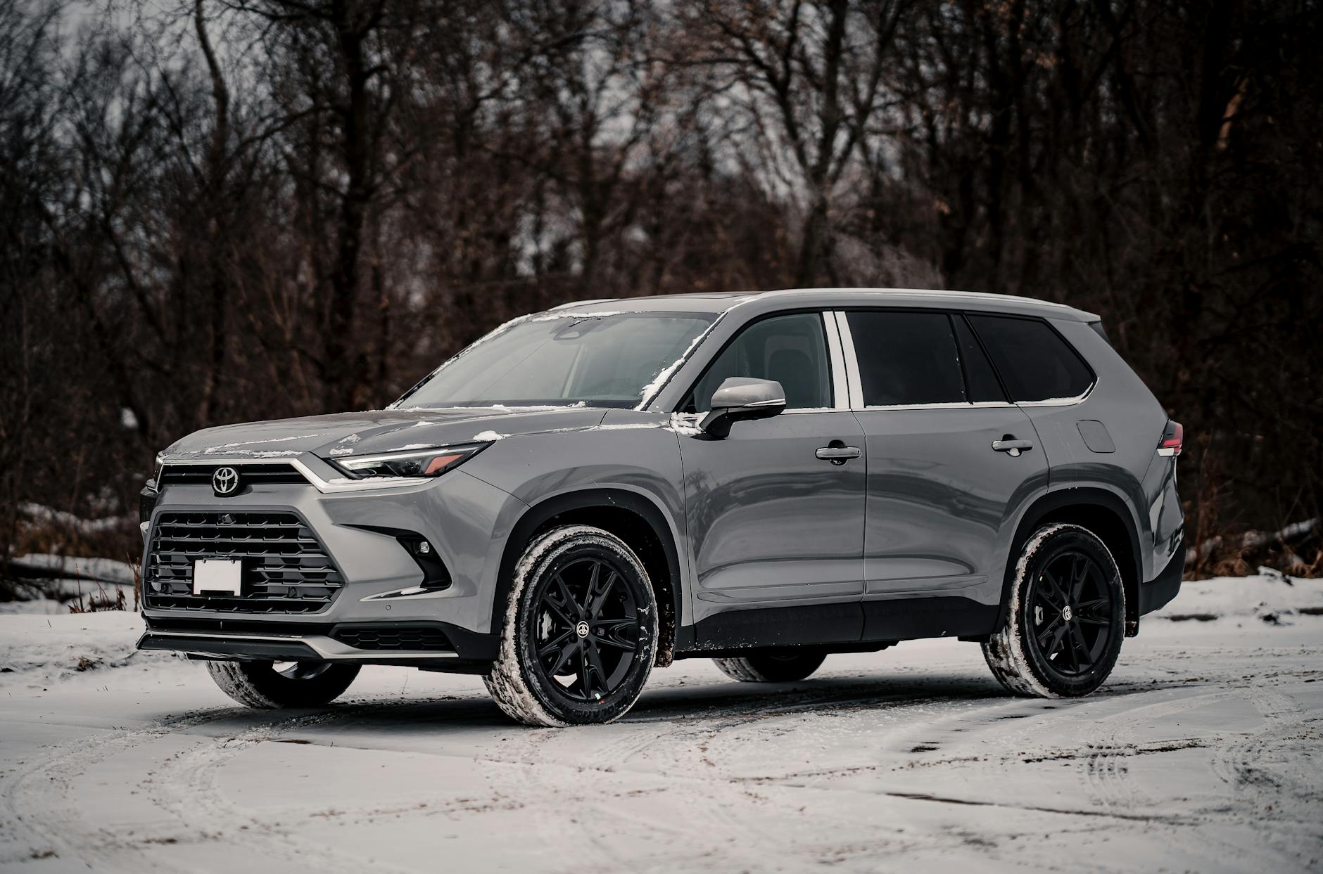 Szary SUV Lamborghini Urus zaparkowany zimą na ośnieżonym terenie