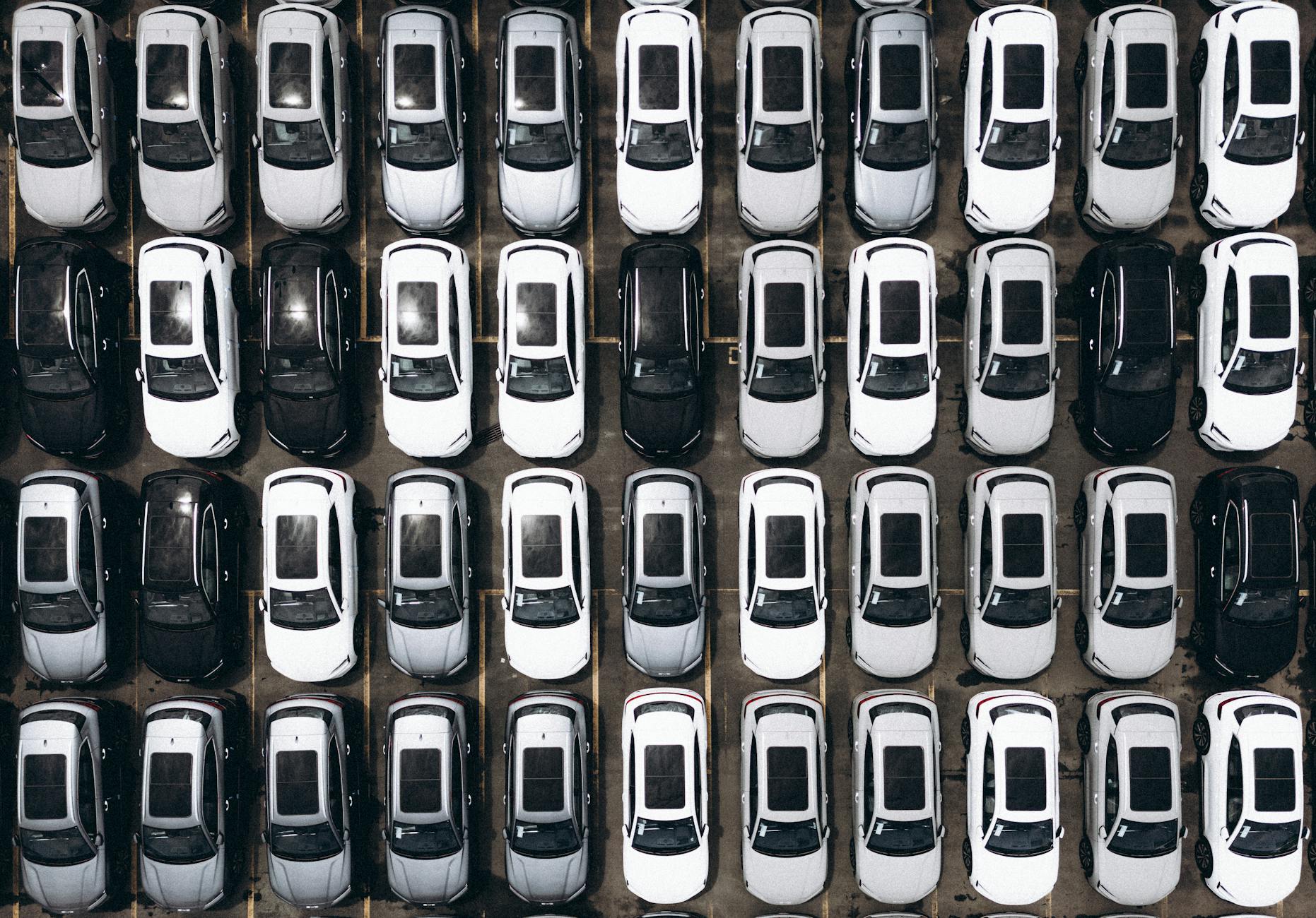 Widok z lotu ptaka na duży parking pełen zaparkowanych samochodów