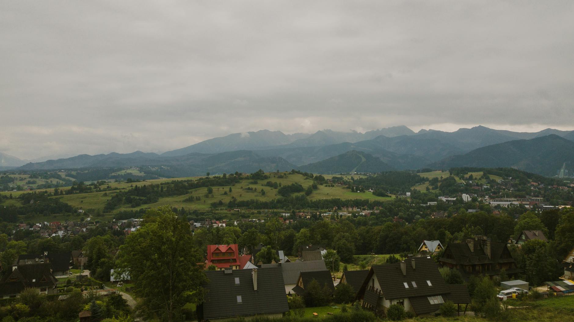 Tatry z lotu ptaka i rozrzucone pośród zieleni domy polskiej wsi